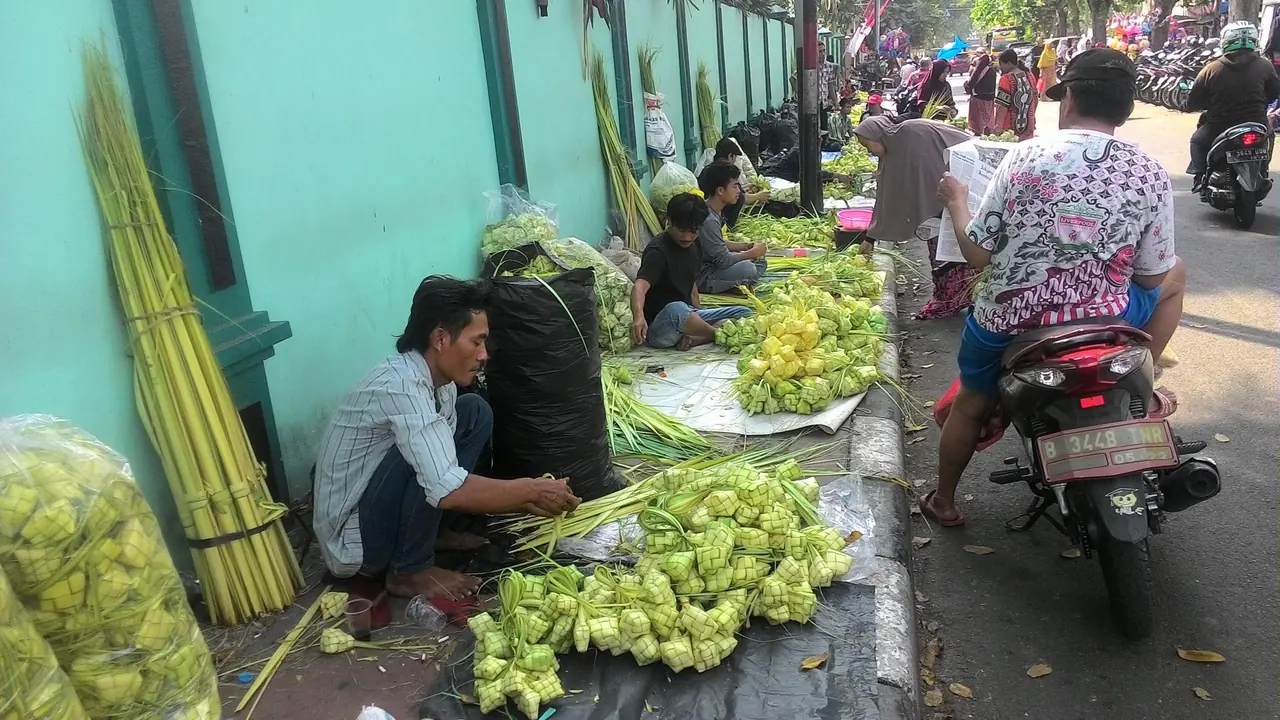 Menganyam ketupat menjelang hari raya Tangan menganyam ketupat dari janur