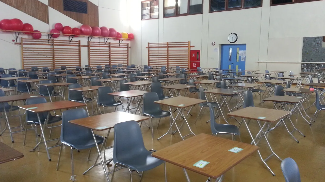 Ruang ujian di sekolah menengah Deretan meja dan kursi tertata rapi di sebuah ruang ujian sekolah menengah